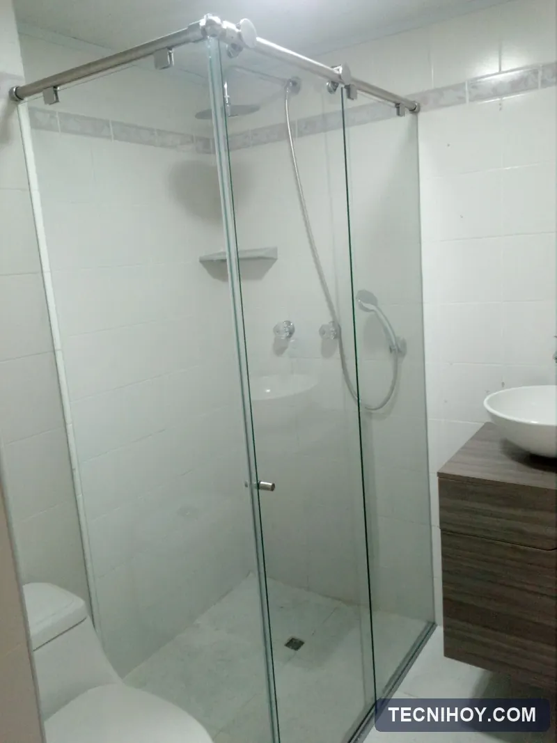 División de baño en L con sistema de corredera en vidrio templado