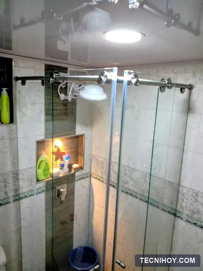 División de baño en L en vidrio templado con accesorios en acero inoxidable