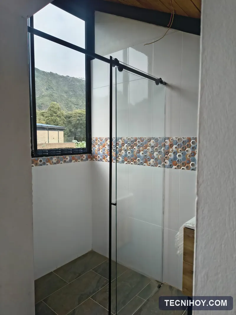 División de baño en vidrio templado con herrajes negros