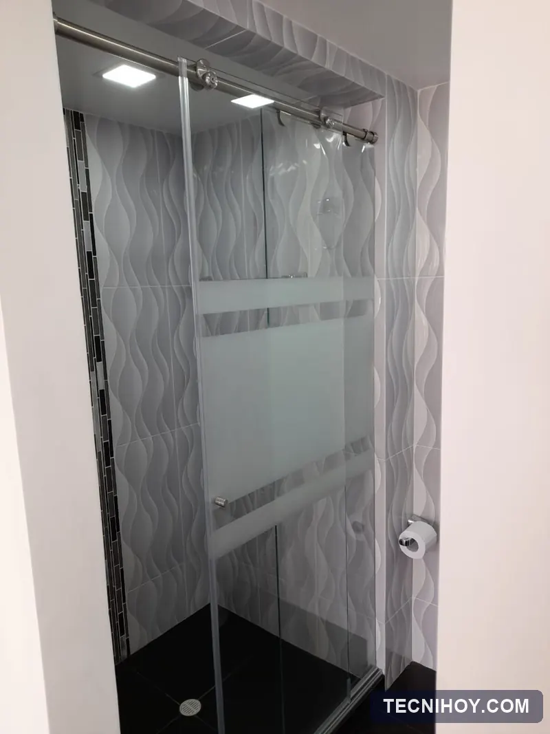 División de baño en vidrio templado con franjas en sandblasting